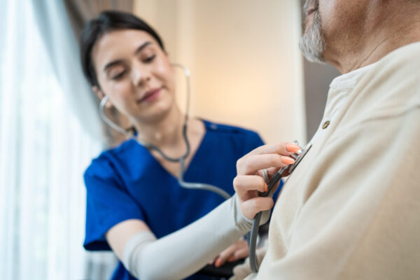 Caregiver listening to a patient's heart who is living with heart failure